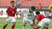 Dua pemain Timnas Indonesia, Ponaryo Astaman (11) dan Harry Saputra mencoba membayangi penyerang Timnas Qatar, Abdulaziz Karim di Piala Asia 2004 (AFP/Frederic Brown)