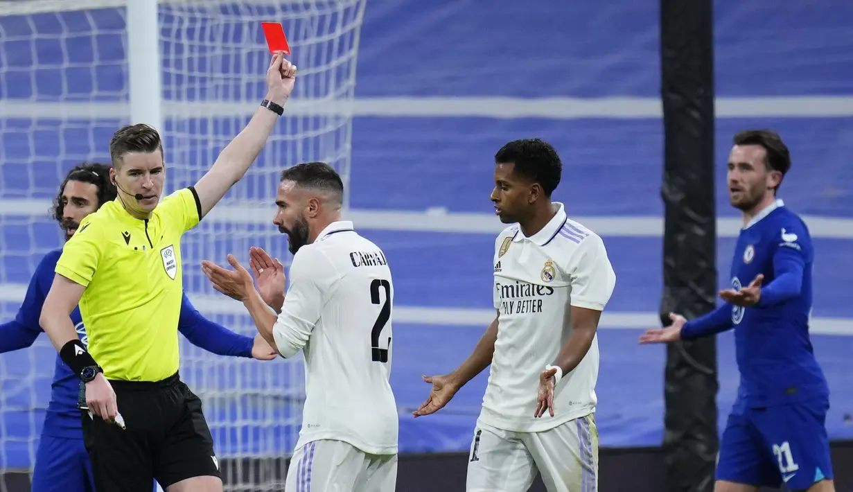 Wasit Francois Letexier (kiri) memberikan kartu merah kepada pemain Chelsea, Ben Chilwell (kanan) pada laga leg pertama perempat final Liga Champions 2022/2023 di Santiago Bernabeu, Madrid, Kamis (13/04/2023) WIB. Los Blancos menang dengan skor 2-0. (AP Photo/Manu Fernandez)