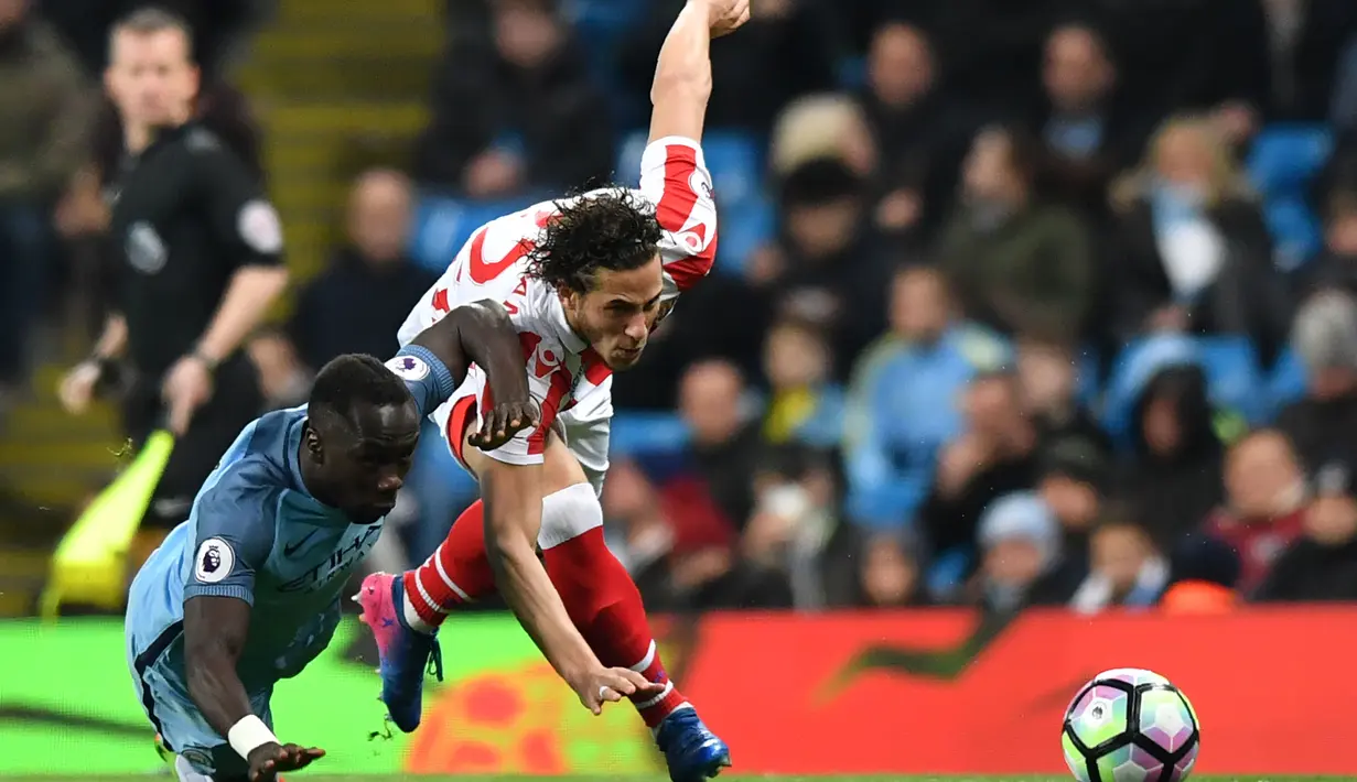 Pemain Manchester City,  Bacary Sagna (kiri) berebut bola dengan pemain Stoke City, Ramadan Sobhi pada lanjutan Premier League di Etihad Stadium, (8/3/2017). Manchester City bermain imbang 0-0.  (AFP/Anthony Devlin)