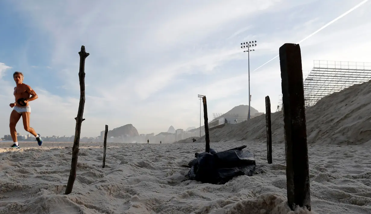 Seorang pria melihat bagian dari tubuh yang terpotong di Pantai Copacabana, Rio de Janeiro, Brasil (29/6). Potongan tubuh  yang ditemukan di dekat arena voli tersebut sontak menggegerkan pengunjung serta pemerintah setempat. (REUTERS/Sergio Moraes)