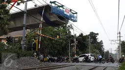 Sejumlah kendaraan melintasi perlintasan kereta api di kawasan Patal Senayan, Jakarta, Selasa (6/10/2015). Pembangunan flyover Permata Hijau di atas perlintasan kereta api di kawasan tersebut sudah mencapai 70 persen. (Liputan6.com/Yoppy Renato)