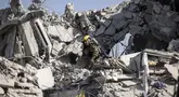 Petugas tanggap darurat Israel memeriksa sebuah lokasi yang terkena rudal yang ditembakkan dari Iran di selatan Tel Aviv pada 14 Juni 2025. (JOHN WESSELS/AFP)