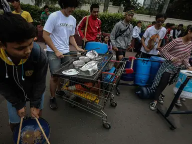 Sejumlah mahasiswa dari Universitas ISIP bermain alat musik dari barang bekas di Car Free Day kawasan Bundaran HI, Jakarta, Minggu (15/1). (Liputan6.com/Faizal Fanani)