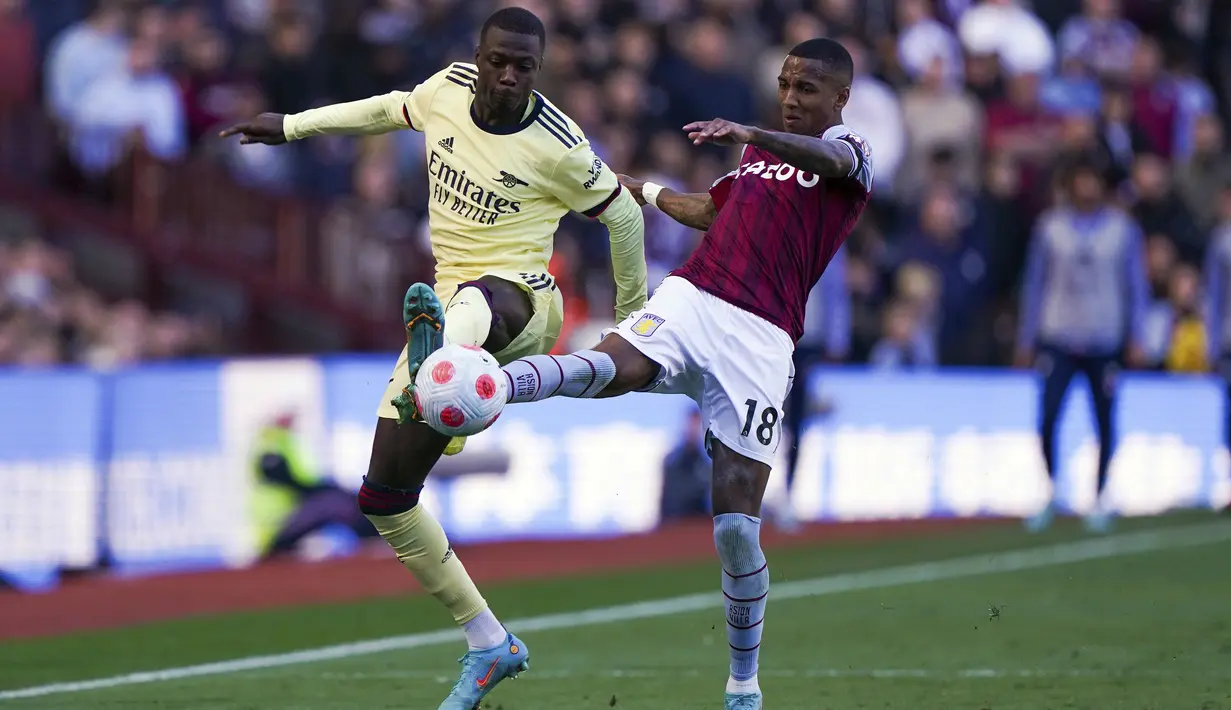 Penyerang Arsenal, pepe berebut bola dengan bek Aston Villa, Ashley Young pada pertandingan lanjutan Liga Inggris di Villa Park, Birmingham, Inggris, Sabtu (19/3/2022). Arsenal menang tipis atas Aston Villa 1-0. (Nick Potts/PA via AP)