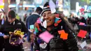 Seorang wanita tersenyum ceria saat bermain confetti dalam perayaan tahun baru di Times Square, New York, AS (1/1). (Reuters/Stephanie Keith)