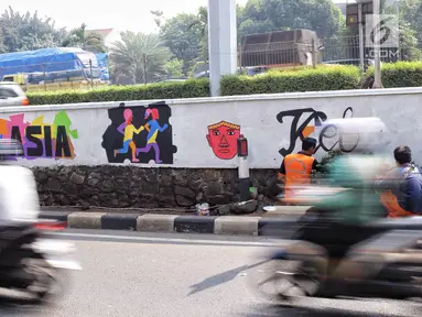 Petugas PSSU menyelesaikan mural bertema Asian Games di kawasan Tanjung Barat, Jakarta, Kamis (31/5). Mural itu dibuat untuk sosialisasi sekaligus bentuk dukungan terhadap perhelatan Asian Games pada Agustus 2018 mendatang. (Liputan6.com/Faizal Fanani)