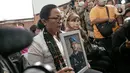 Ibunda Nofriansyah Yosua Hutabarat atau Brigadir J, Rosti Simanjuntak membawa foto sang anak saat menghadiri sidang vonis terdakwa Ferdy Sambo di Pengadilan Negeri Jakarta Selatan, Senin (13/2/2023). Rosti didampingi kuasa hukum keluarga Martin Lukas Simanjuntak menonton langsung sidang putusan terhadap Ferdy Sambo. (Liputan6.com/Faizal Fanani)