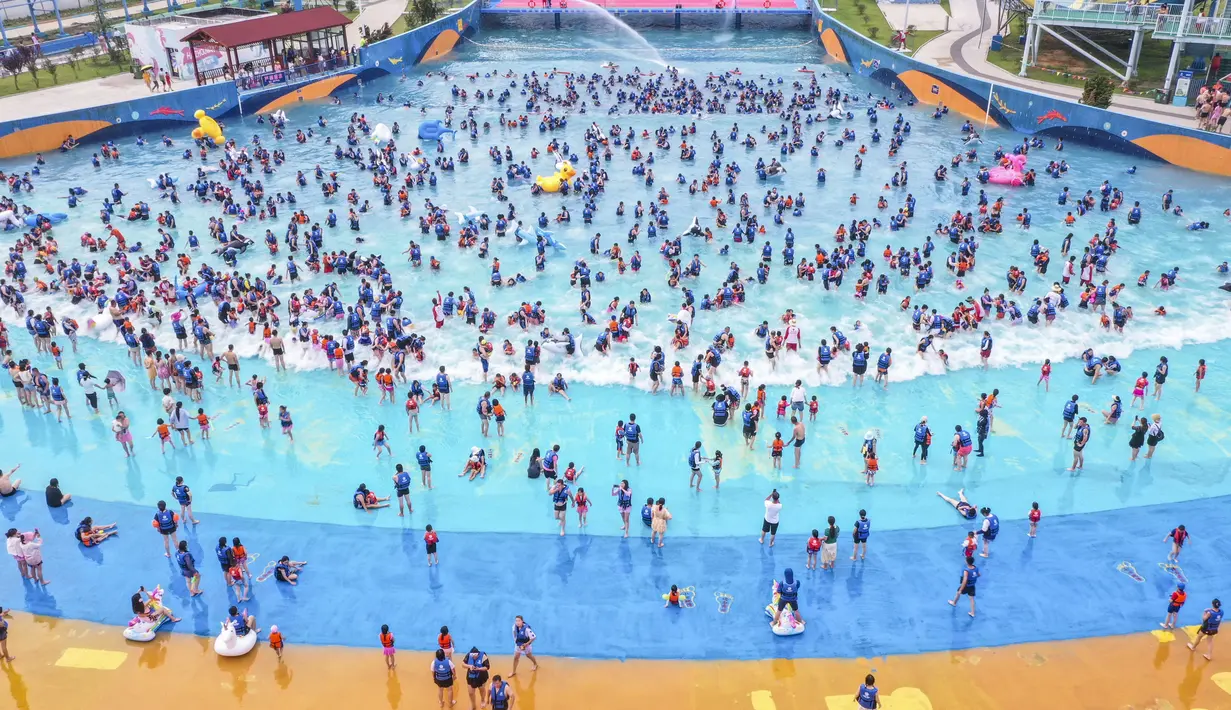 Suasana foto udara warga China bersantai di kolam renang Lianyungang, provinsi Jiangsu timur, China (4/7/2021). Di tengah pandemi Covid-19, warga China asyik menonton pertunjukan papan luncur saat mereka mendinginkan diri di kolam renang sambil bersantai. (AFP/STR)