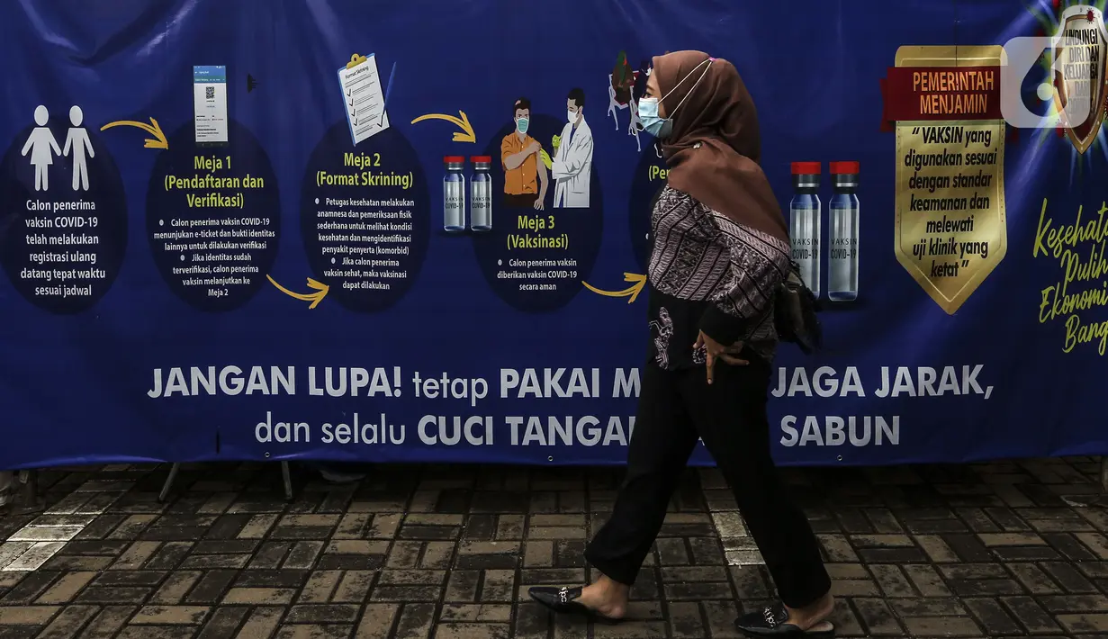 Seorang wanita berjalan melintasi lokasi penyuntikkan vaksin COVID-19 Sinovac kepada tenaga kesehatan di Puskesmas Palmerah, Jakarta, Kamis (28/1/2021). Pemberian vaksin COVID-19 tahap kedua dilaksanakan terhadap tenaga kesehatan mulai hari ini. (Liputan6.com/Johan Tallo)