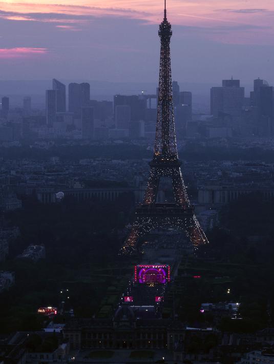 Pemandangan Menara Eiffel dan kota Paris saat acara Champs de Mars yang digelar untuk menyambut Piala Eropa 2016 di Paris fan zone, belakang Menara Eiffel, Prancis, Jumat (10/6/2016). (AFP/Geoffroy Van Der Hasselt)