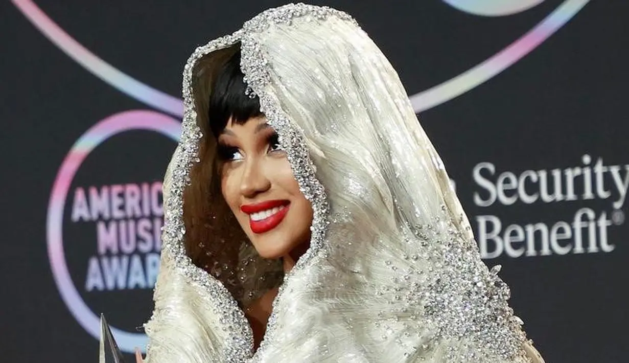 <p>Didapuk sebagai host acara AMAs, pelantun &ldquo;I Like It&rdquo; itu kembali membuat heboh dengan berganti pakaian menjadi gaun putih dan hiasan kepala berbulu sepanjang lantai. (Instagram/amas)</p>