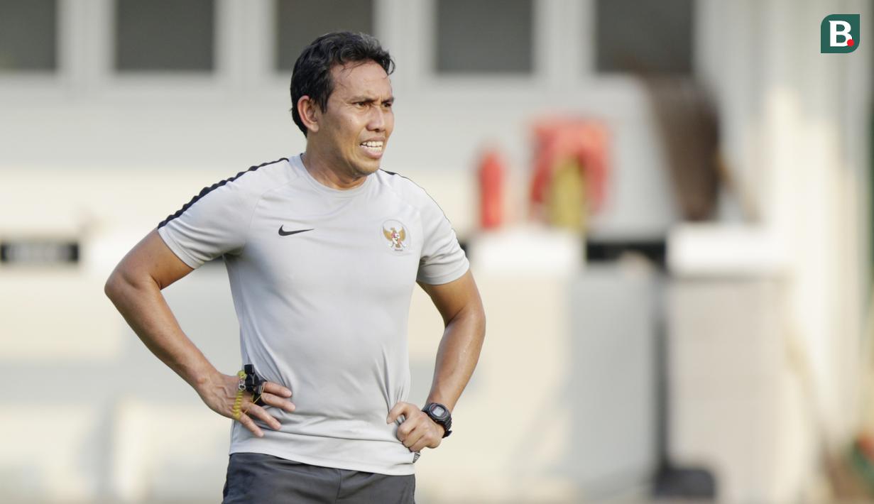 Pelatih Timnas Indonesia, Bima Sakti, mengamati anak asuhnya saat latihan di Universitas Kasetsart, Bangkok, Kamis (15/11). Latihan ini persiapan jelang laga Piala AFF 2018 melawan Thailand. (Bola.com/M. Iqbal Ichsan)