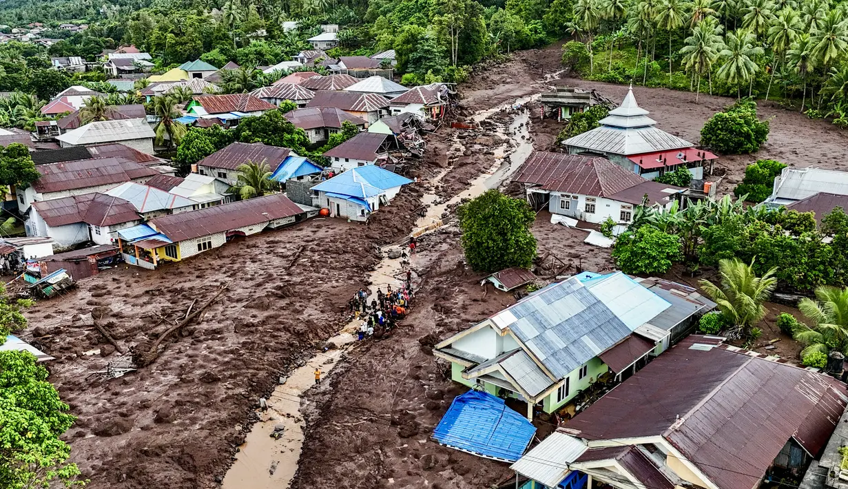 Foto udara tim penyelamat dan warga melakukan pencarian korban yang tertimbun akibat banjir bandangdi Kelurahan Rua, Kota Ternate, Maluku Utara, Minggu (25/8/2024). (AZZAM RISQULLAH / AFP)