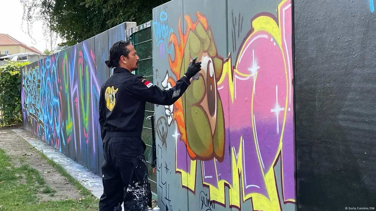 Emet melukis tembok di Berlin dengan karakter grafitinya. (Sorta Caroline/DW)
