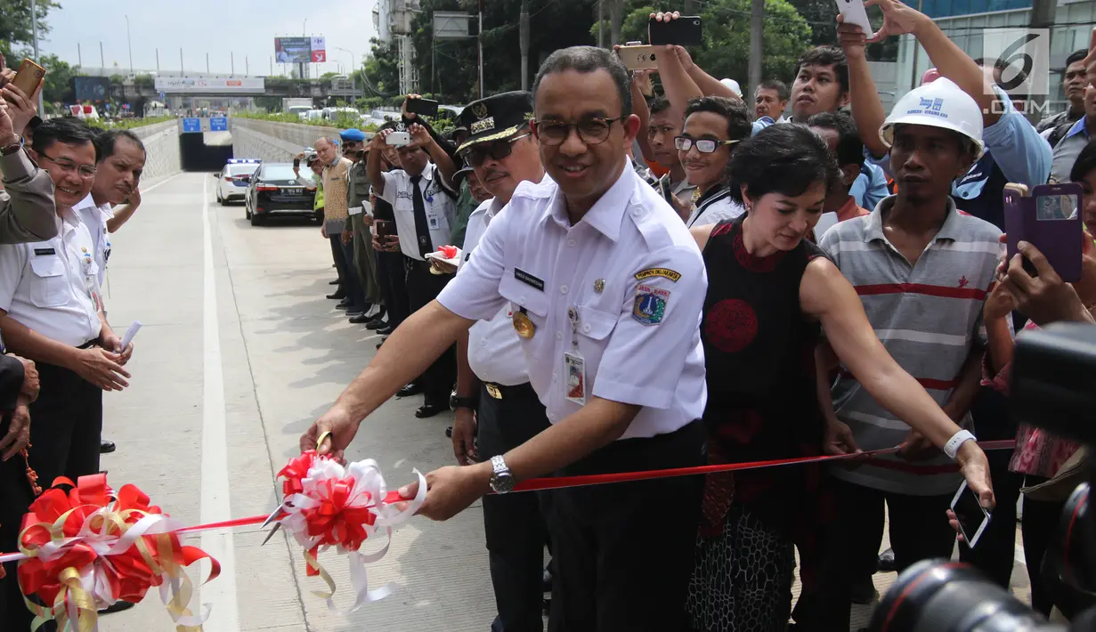 Gubernur DKI Jakarta Anies Baswedan memotong pita saat peresmian Lintas Bawah Kartini, Jakarta Selatan, Rabu (28/2). Lintas Bawah Kartini ini memiliki panjang 500 meter dan tertutup terowongan sepanjang 120 meter. (Liputan6.com/Arya Manggala)