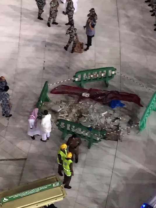 Sejumlah petugas berkumpul di dekat kerusakan yang disebabkan jatuhnya alat berat proyek (crane) di Masjidil Haram, Mekkah, Jumat (11/9/2015). Sebanyak 107 orang dilaporkan tewas, termasuk warga negara Indonesia. (AFP PHOTO / STR)