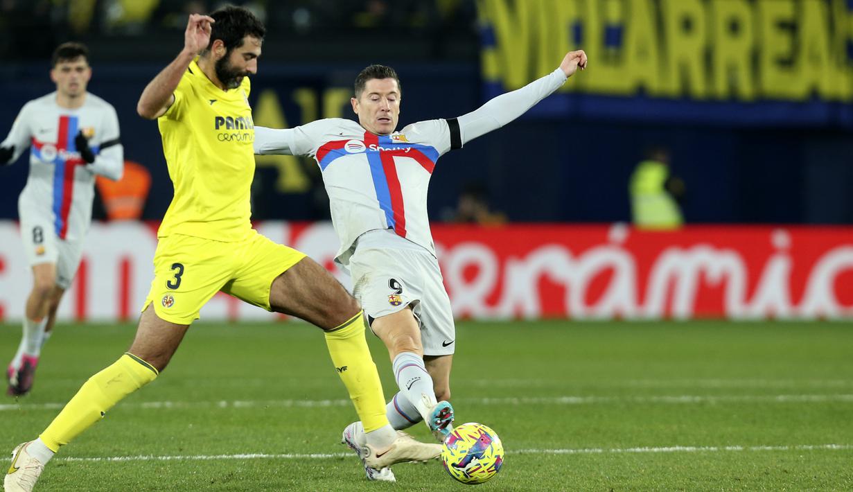 <p>Penyerang Barcelona, Robert Lewandowski berusaha merebut bola dari bek Villarreal, Raul Albiol selama pertandingan lanjutan La Liga Spanyol di stadion Ceramica di Villarreal, Spanyol, Senin (13/2/2023). Kemenangan ini membuat Barcelona makin kokoh di puncaki klasemen. (AP Photo/Alberto Saiz)</p>