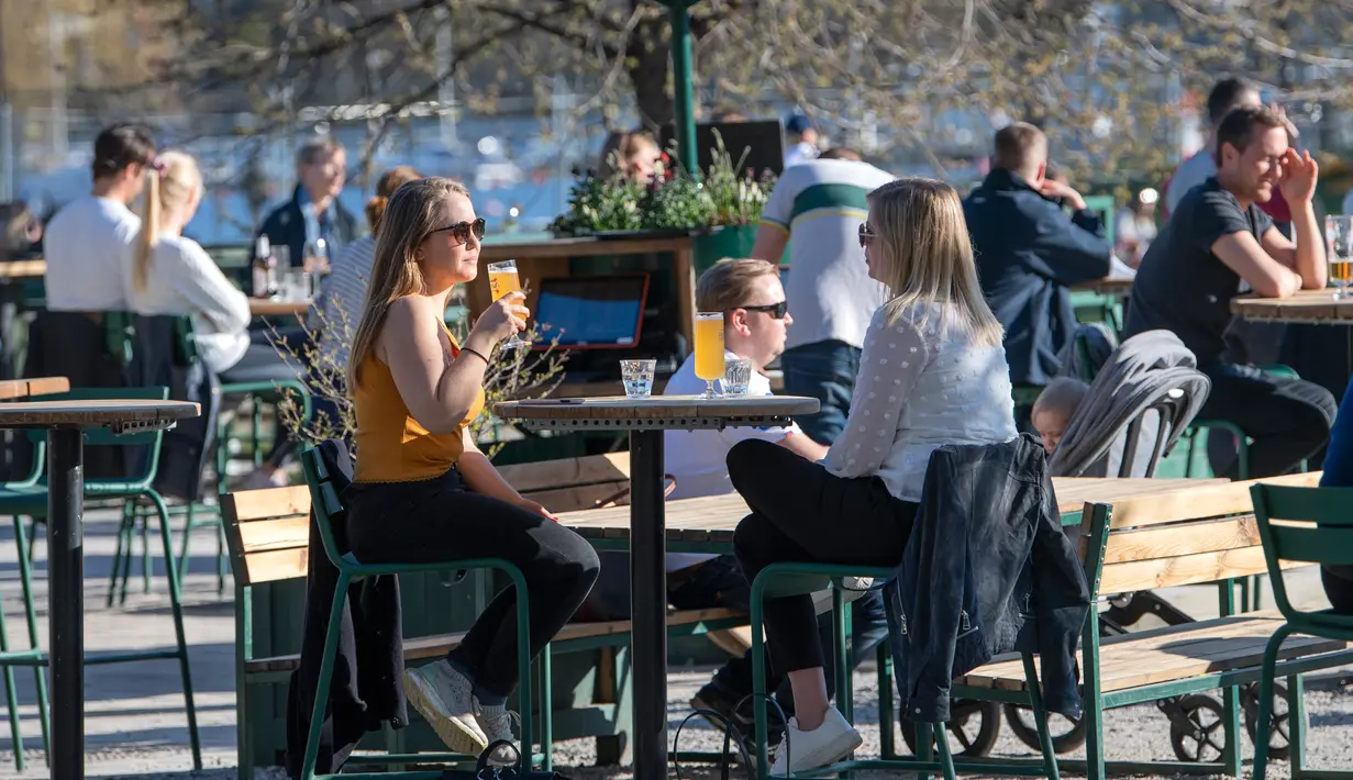 Orang-orang menikmati cuaca hangat di Stockholm, Rabu (22/4/2020). Swedia belum memberlakukan lockdown, seperti mayoritas negara Eropa lainnya, namum pemerintah memberikan tanggung jawab besar kepada penduduknya untuk membantu mengurangi penyebaran virus corona. (Anders WIKLUND/TT NEWS AGENCY/AFP)