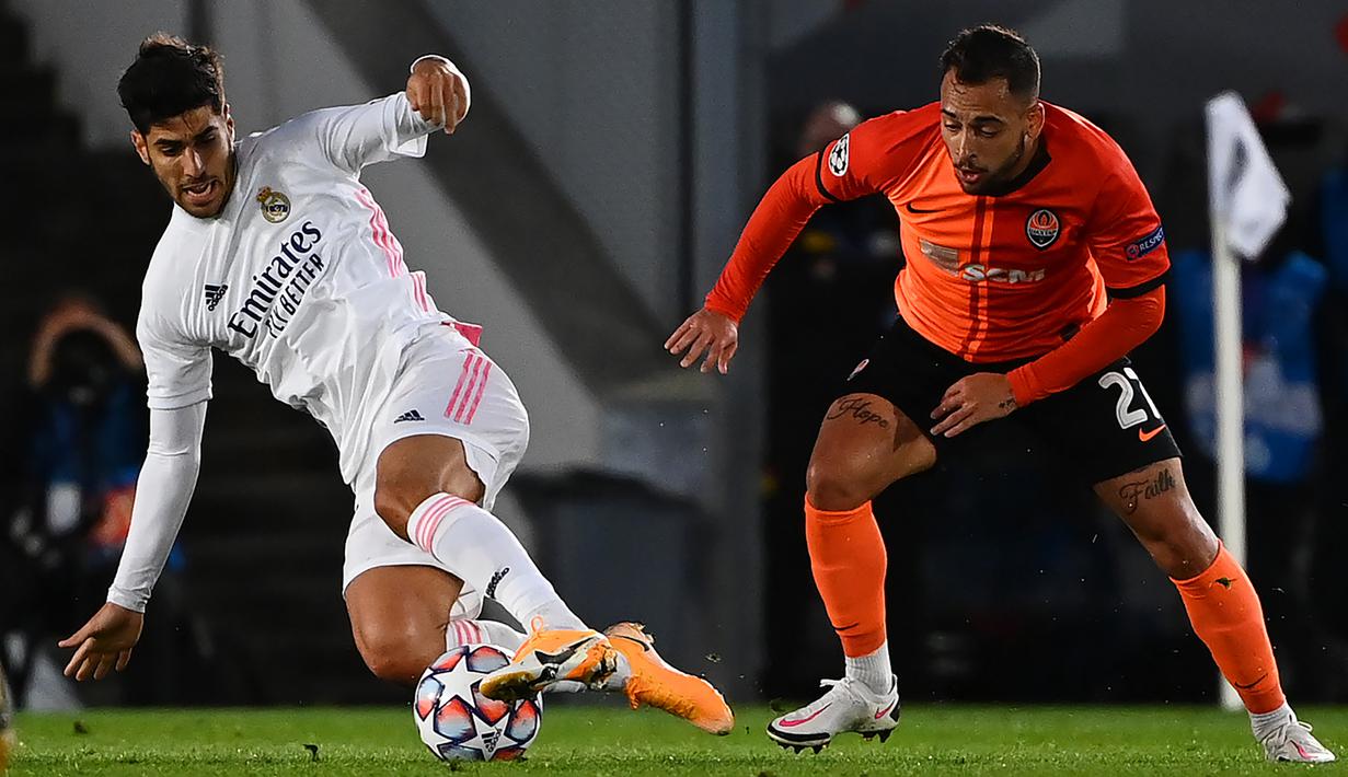 Penyerang Real Madrid, Marco Asensio, berebut bola dengan gelandang Shaktar Donetsk, Maycon, pada laga Liga Champions 2020/2021 di Estadio Alfredo Di Stefano, Rabu (21/10/2020) malam WIB. Real Madrid kalah 2-3 oleh Shaktar Donetsk. (AFP/Gabriel Bouys)
