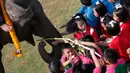 Sejumlah anak-anak sekolah memberi makan gajah sebelum pertandingan Polo gajah di Bangkok, Thailand (8/3). Acara amal ini memperebutkan Piala Raja Gajah yang digelar tiap tahun. (AP Photo / Sakchai Lalit)