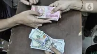 Seorang warga menjual uang dolar Amerika Serikat di salah satu gerai money changer di Jakarta, Senin (4/7/2022). Rupiah kembali melemah melawan dolar Amerika Serikat (AS) pada perdagangan mendekati lagi Rp15.000 per USD 1 dan menjadi salah satu yang terburuk. (merdeka.com/Iqbal S Nugroho)