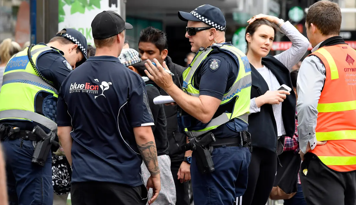 Polisi mendengarkan keterangan saksi terkait sebuah mobil yang menghantam pejalan kaki di pusat kota Melbourne, Australia, Jumat (20/1). Pria yang diduga sebagai pelaku sudah ditangkap, namun belum diketahui motif perbuatannya. (AP Photo/Andrew Brownbill)