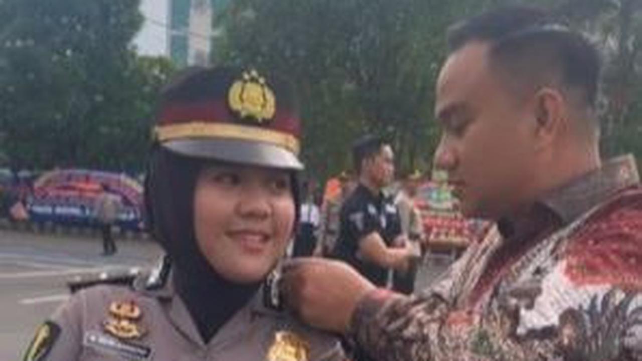 Pria ini memasangkan pangkat baru sang istri dengan penuh kasih sayang. Diketahui sang istri mendapatkan kenaikan pangkat menjadi Iptu. <br>