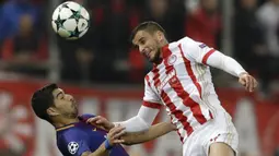 Striker Barcelona, Luis Suarez, duel udara dengan bek Olympiakos, Omar Elabdellaoui, pada laga Liga Champions di Stadion Karaiskakis, Selasa (31/10/2017). Barcelona bermain imbang 0-0 dengan Olympiakos. (AP/Thanassis Stavrakis)