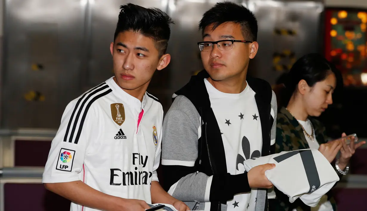 Para fans real madrid saat menunggu kedatangan pemain Real Madrid di Bandara Manchester, Inggris, (25/4).Real Madrid lolos ke semifinal setelah sebelumnya menang melawan Wolfsburg. (Reuters / Phil Noble)