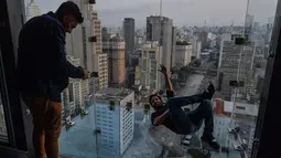 Seorang pengunjung berpose di Sampa Sky Observation Deck di Sao Paulo, Brasil pada 05 Agustus 2021. Gedung tersebut terinspirasi dari Skydeck Chicago di Amerika Serikat yang memiliki tinggi 103 lantai. (NELSON ALMEIDA / AFP)