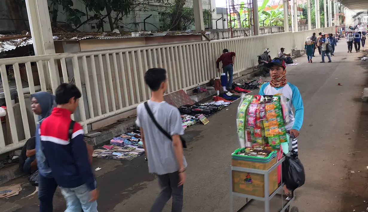 Suasana kolong skybridge atau Jembatan Penyebrangan Multifungsi (JPM) Tanah Abang, Jakarta, Rabu (7/11). Molornya pembangunan skybridge menyebabkan PKL kembali menjajakan dagangannya, meskipun dilarang Pemprov DKI Jakarta. (Liputan6.com/Immanuel Antonius)