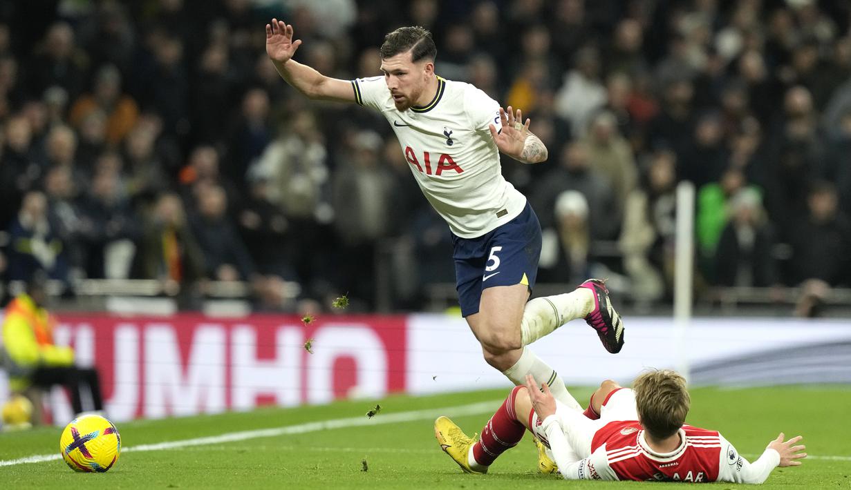 Bek Tottenham Hotspur, Pierre-Emile Hojbjerg berusaha melewati gelandang Arsenal, Martin Odegaard pada pertandingan lanjutan Liga Inggris di Stadion Tottenham Hotspur di London, Inggris, Minggu (15/1/2023). Hasil ini membuat Arsenal makin kokoh di puncak klasemen dengan koleksi 47 angka dari 18 laga. (AP Photo/Frank Augstein)