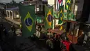 Bendera Brasil digantung di atas traktor yang menarik trailer penggemar sepak bola dan musisi ke rumah Alberto Izquierdo, presiden asosiasi penggemar tim Brasil, untuk menonton pertandingan Grup G Piala Dunia 2022 antara Brasil vs Swiss  di Bauta, Kuba, Senin (28/11/2022). Orang-orang di kotamadya Bauta telah berkumpul untuk mendukung tim Brasil di setiap Piala Dunia selama 20 tahun terakhir. (AP Photo/Ramon Espinosa)