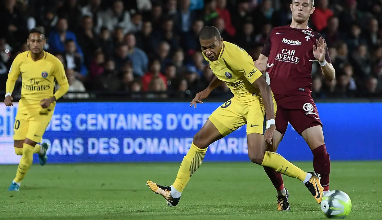 Penyerang PSG, Kylian Mbappe, berebut bola dengan bek Metz, Chris Philipps, pada laga Ligue 1 Prancis di Stadion Saint-Symphorien, Moselle, Jumat (8/9/2017). Metz kalah 1-5 dari PSG. (AFP/Patrick Hertzog)