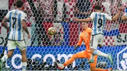 Penyerang Argentina, Julian Alvarez menendang bola melewati kiper Kroasia Dominik Livakovic untuk mencetak gol kedua timnya pada pertandingan semifinal Piala Dunia 2022 di Stadion Lusail di Lusail, Qatar, Rabu (14/12/2022). Argentina berhasil lolos ke final setelah menang telak atas Kroasia dengan skor 3-0. (AP Photo/Petr David Josek)