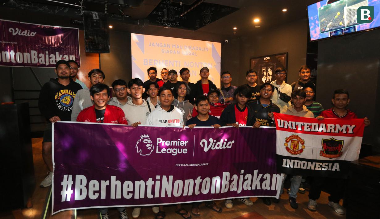 Penonton berfoto bersama setelah acara Roaring Night Manchester United melawan West Ham yang berlangsung di Fomo Bar, Melawai, Jakarta, Minggu (04/02/2024) malam WIB. (Bola.com/Bagaskara Lazuardi)