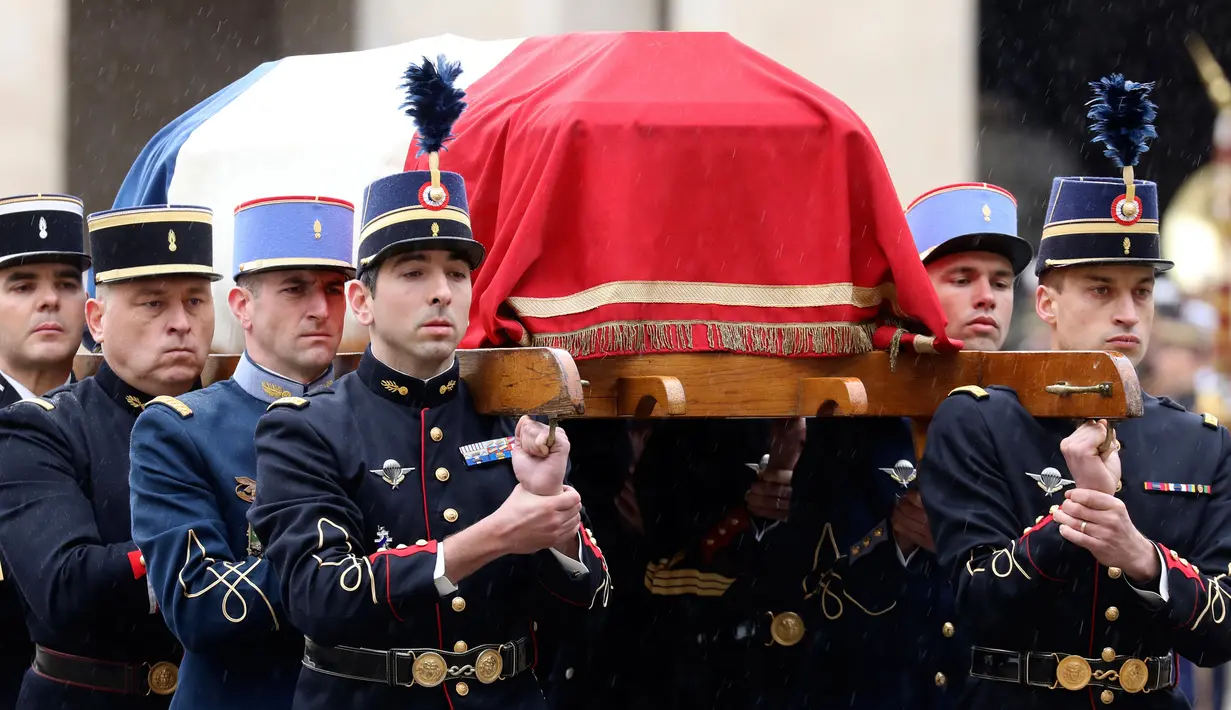 Anggota kepolisian Prancis menggotong peti mati Letnan Kolonel Arnaud Beltrame dalam upacara nasional di Hotel des Invalides, Paris, Rabu (28/3). Beltrame merupakan polisi yang menawarkan diri bertukar tempat dengan sandera dalam aksi terorisme (AP Photo)