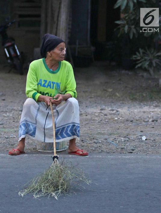 Warga membawa sapu menunggu pengguna jalan memberi sedekah dengan melempar uang di Jembatan Sewo, Jalur Pantura Sukra Indramayu, Jawa Barat, Senin (3/6/2019). Keberadaan pencari sedekah bisa membahayakan keselamatan pemudik serta pengguna jalan lainnya. (Liputan6.com/Herman Zakharia)