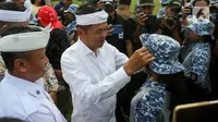 Gubernur Jawa Barat Dedi Mulyadi merapikan topi yang dikenakan salah satu siswa peserta program Pembinaan Karakter dan Bela Negara di lapangan Markas Divisi Infanteri 1 Kostrad, Cilodong, Kota Depok, Senin (9/6/2025). (Liputan6.com/Herman Zakharia)