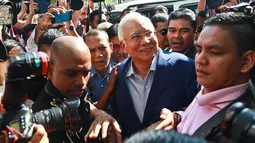 Mantan Perdana Menteri Najib Razak tiba di kantor Komisi Anti-Korupsi Malaysia (MACC) untuk menjalani pemeriksaan di Putrajaya, Selasa (22/5). Tersenyum santai, Najib Razak memasuki gedung MACC dengan pengawalan ketat petugas keamanan. (AP/Sadiq Asyraf)
