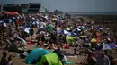 Orang-orang bersantai di kawasan Southend-on-Sea, bagian tenggara Inggris pada 12 Agustus 2024. (HENRY NICHOLLS/AFP)