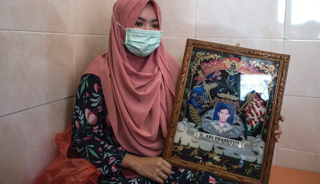 Berda Asmara menunjukkan foto suaminya Serda Mes Guntur Ari Prasetyo di rumah mereka di Surabaya, Jumat (23/4/2021). Kapal selam KRI Nanggala yang diawaki Serda Mes Guntur Ari Prasetyo dan 52 kru lainnya hilang kontak saat sedang melaksanakan latihan penembakan dengan torpedo. (Juni Kriswanto/AFP)