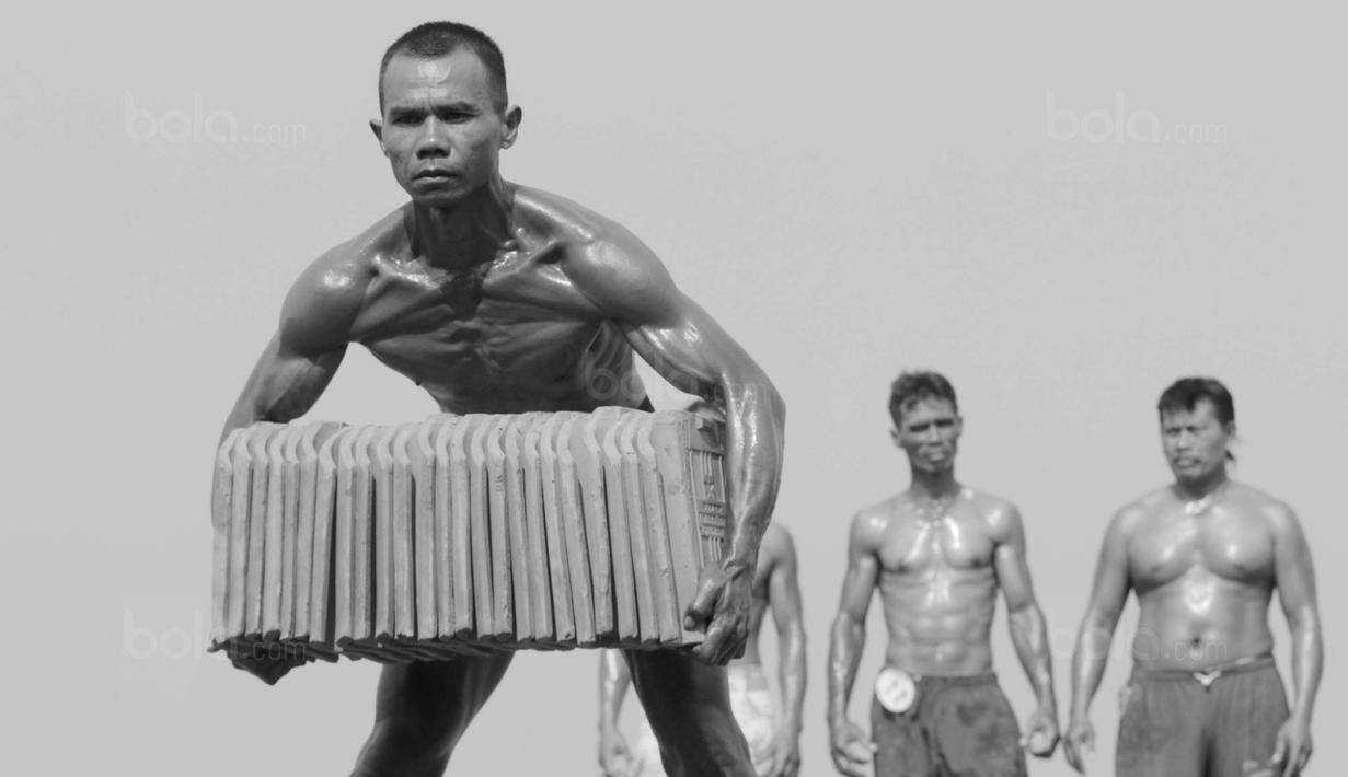 Peserta menunjukan keahliannya mengangkat genteng saat mengikuti kontes binaraga di Desa Jatiwangi, Majalengka, Jawa Barat, (11/8/2017). Kontes yang digelar setiap tahun ini merupakan bagian dari perayaan HUT kemerdekaan RI. (Bola.com/M iqbal Ichsan)