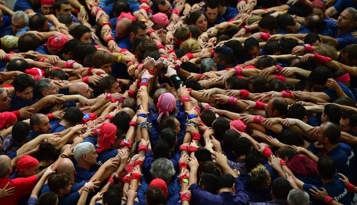 Kompetisi Taragon Castells terinspirasi dari kegiatan kelompok penari pada abad ke-18, Spanyol, Sabtu (1/10). Tim dinyatakan menang apabila berhasil membuat menara manusia yang tertinggi. (AFP PHOTO / Lluis Gene)