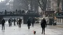 Seorang wanita membawa anjingnya berjalan melintasi permukaan kanal Prinsengracht yang membeku di Amsterdam, Belanda, Jumat (2/3). Untuk pertama kalinya dalam enam tahun, bagian kanal bersejarah di Amsterdam tersebut membeku. (AP/Mike Corder)