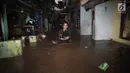 Warga menerjang banjir yang menggenangi Jalan Kebon Pala, Kampung Melayu, Jatinegara, Jakarta Timur, Senin (5/2). Luapan Kali Ciliwung ini juga membuat aktivitas warga sekitar terganggu. (Liputan6.com/Arya Manggala)