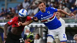 Pemain AC Milan Fikayo Tomori (kiri) berebut bola dengan pemain Sampdoria Manolo Gabbiadini pada pertandingan Serie A di Stadion Luigi Ferraris, Genova, Italia, 23 Agustus 2021. AC Milan menang 1-0. (MIGUEL MEDINA/AFP)