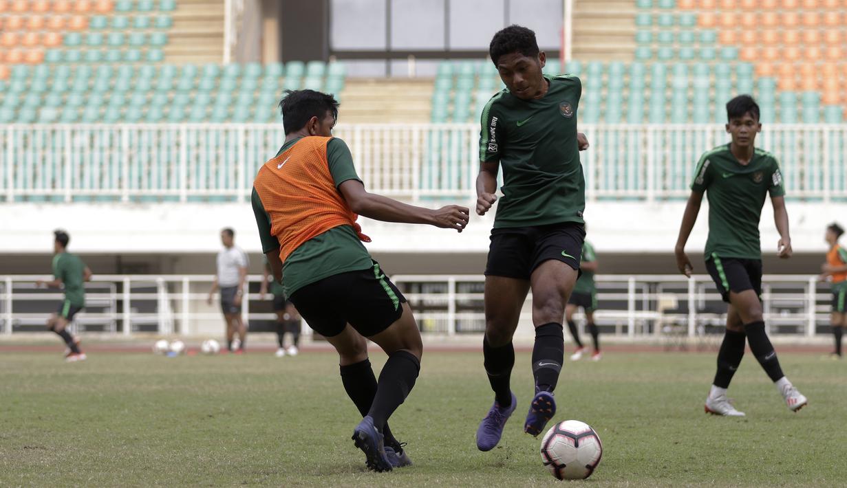 Pemain Timnas Indonesia U-19, Fajar Fathur Rahman, berebut bola saat latihan di Stadion Pakansari, Bogor, Rabu (2/10). Latihan ini merupakan persiapan jelang AFF U-19 di Vietnam. (Bola.com/Yoppy Renato)