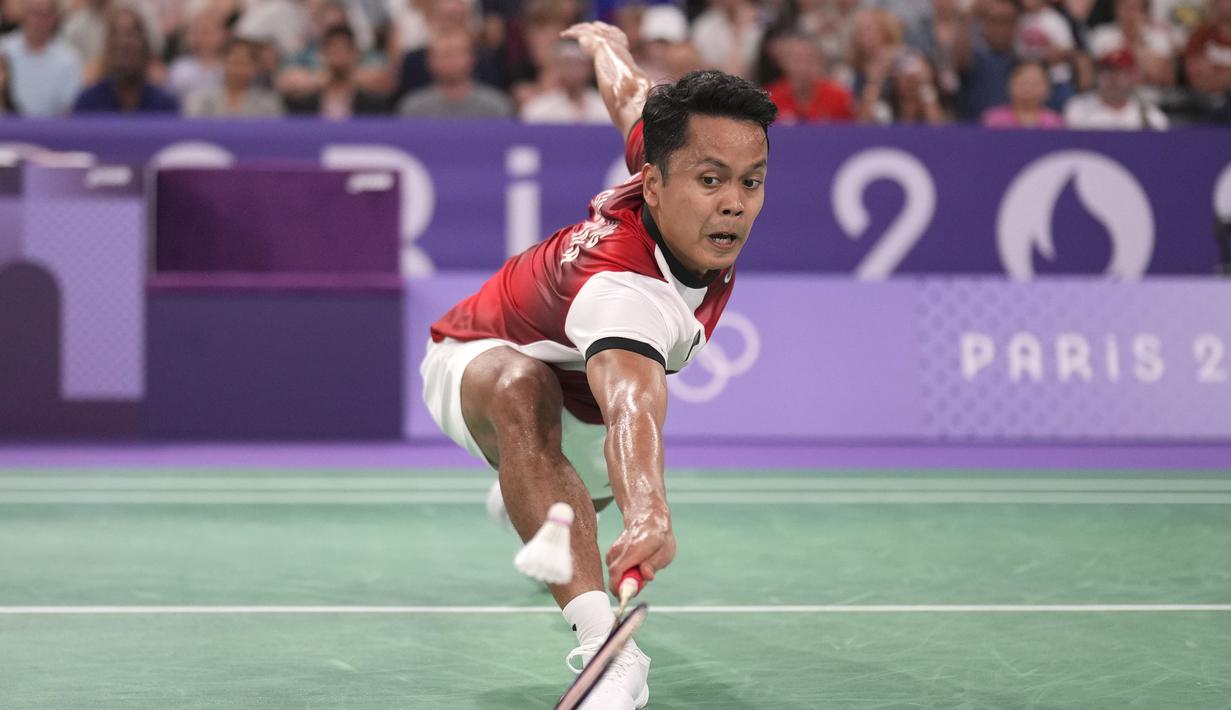 <p>Pemain tunggal putra Indonesia, Anthony Sinisuka Ginting berusaha menjangkau bola saat menghadapi wakil Amerika Serikat, Howard Shu pada laga Grup H bulu tangkis Olimpiade Paris 2024 di Porte de la Chapelle Arena, Prancis, Minggu (28/7/2024). Anthony Sinisuka Ginting menang straight game 21-14, 21-8. (AP Photo/Dita Alangkara)</p>