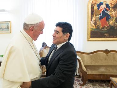 Paus Fransiskus (kiri) bersalaman dengan mantan pesepak bola Argentina, Diego Armando Maradona sebelum pertemuan dengan anggota organisasi Scholas Occurentes di Vatikan pada tanggal 4 September 2014. (AFP/Filippo Monteforte)